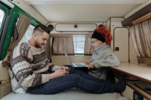 A couple sits in their RV planning out their next adventure