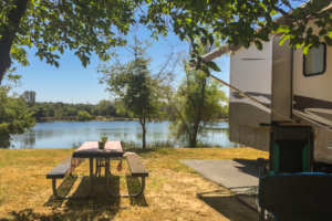 An RV parked in a seasonal campsite next to the water