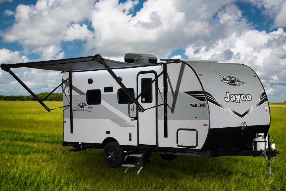 A Jayco travel trailer sits parked in an open field on a cloudy day.