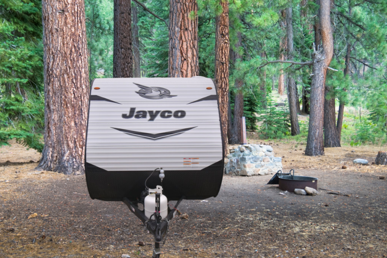 Jayco Jay Flight travel trailer parked in a wooded campsite