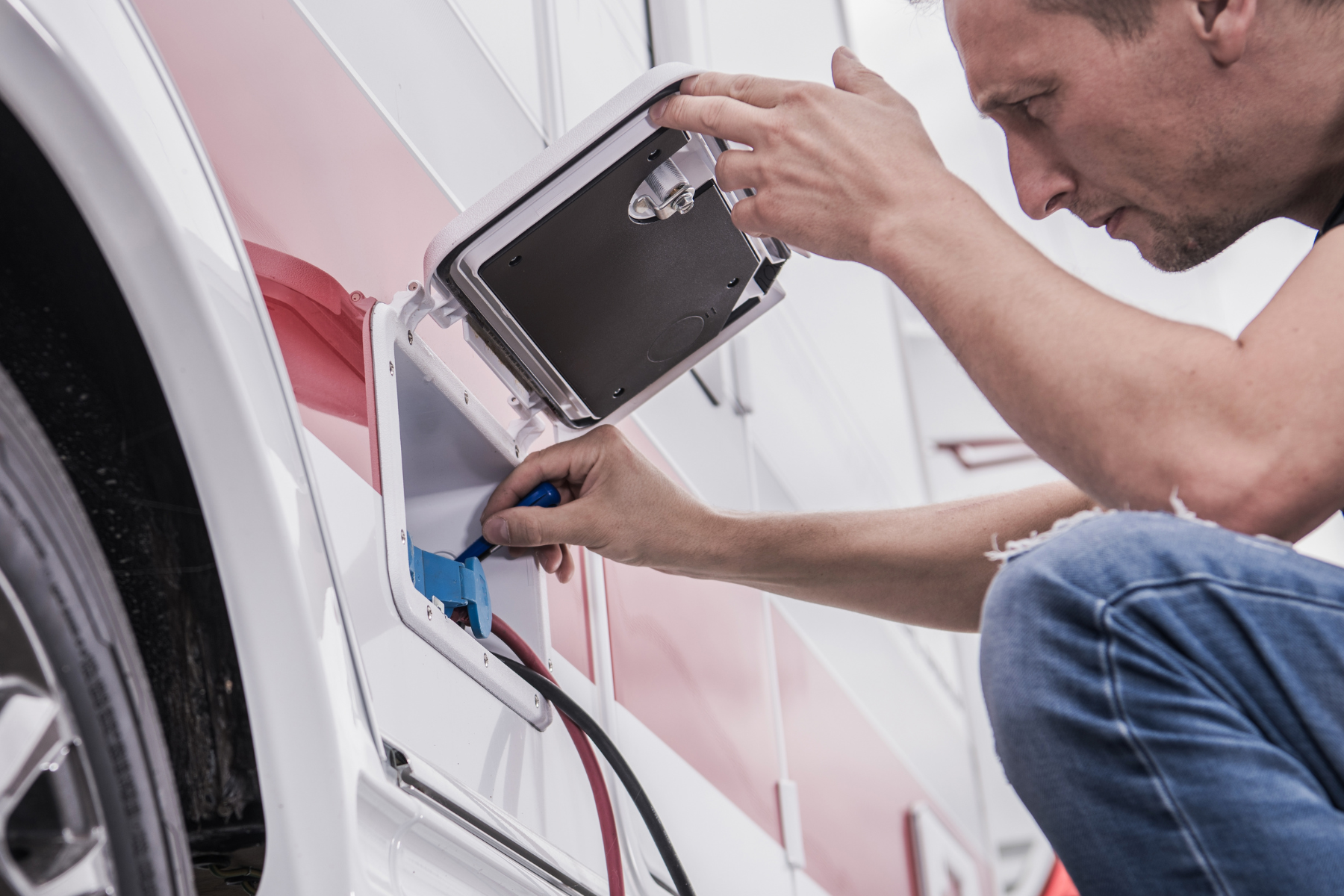 A man inspects the electrical on a travel trailer